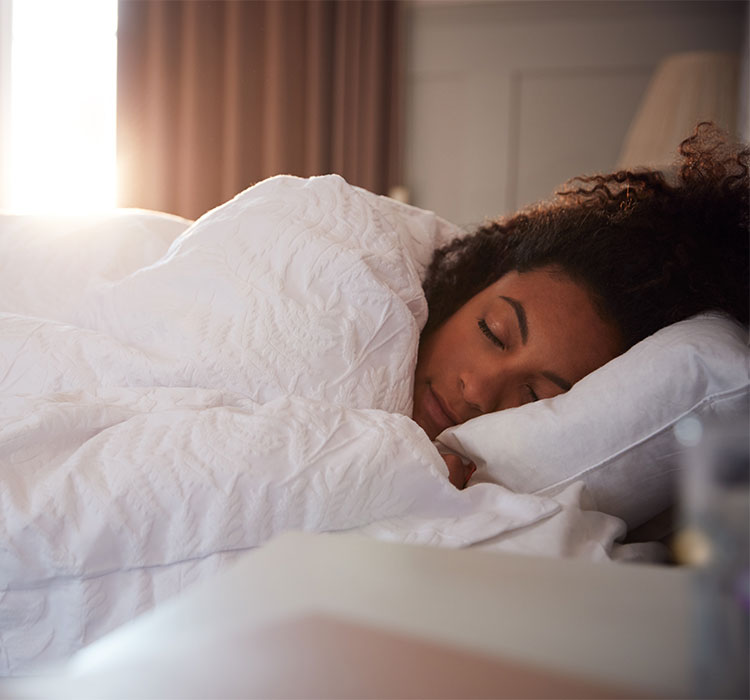 Peaceful Woman Asleep In Bed As Day Break Through Curtains