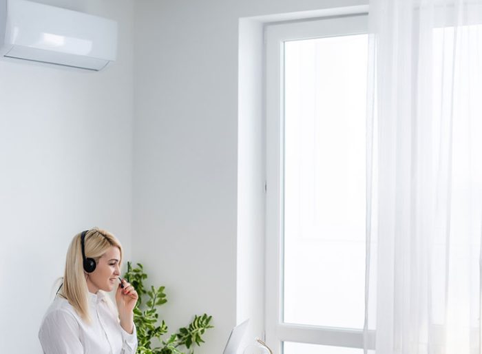 Happy Young Businesswoman Working In Office With Air Conditioning